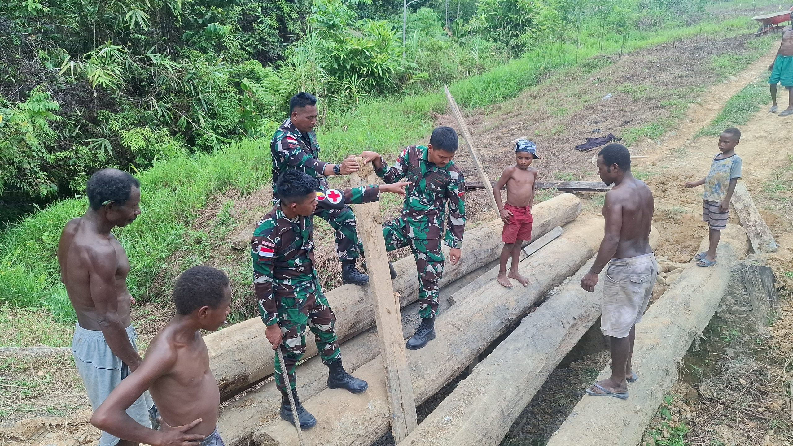 Semangat Gotong Royong, Satgas Yonif 512QY Bersama Masyarakat Perbaiki Jembatan Rusak di Kampung Unggalom.